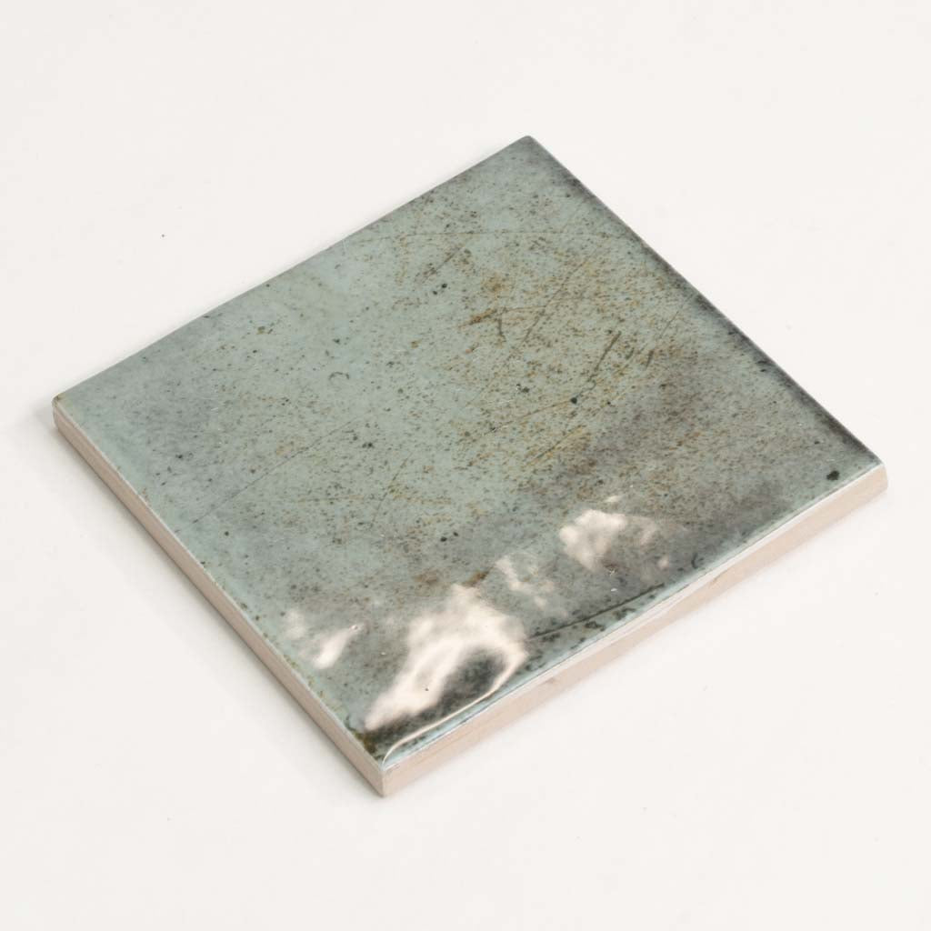 Glossy sage green ceramic square tile 4x4 inches with subtle texture and reflective surface