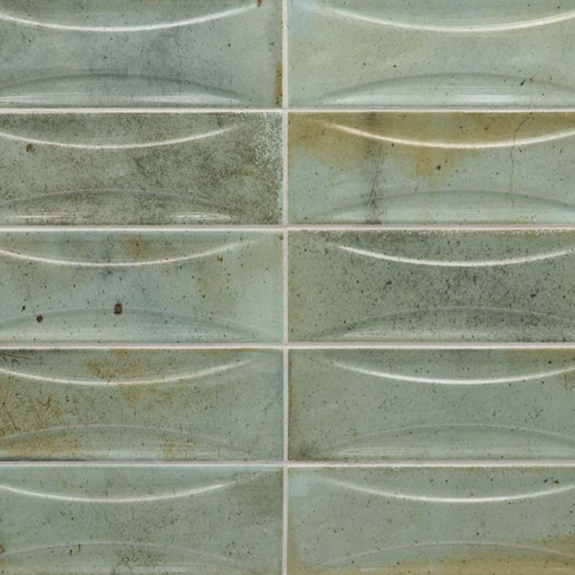 Glossy sage green 2.5x8 ceramic subway deco tiles with subtle curved texture and rustic speckled finish