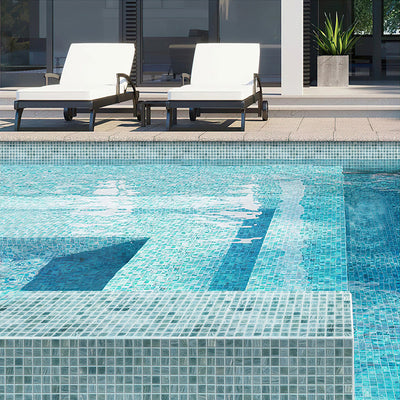 glossy blue glass mosaic tiles installed in swimming pool with water reflections